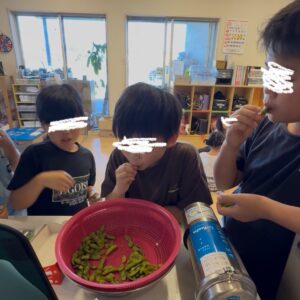 栽培した枝豆を食べる子ども
