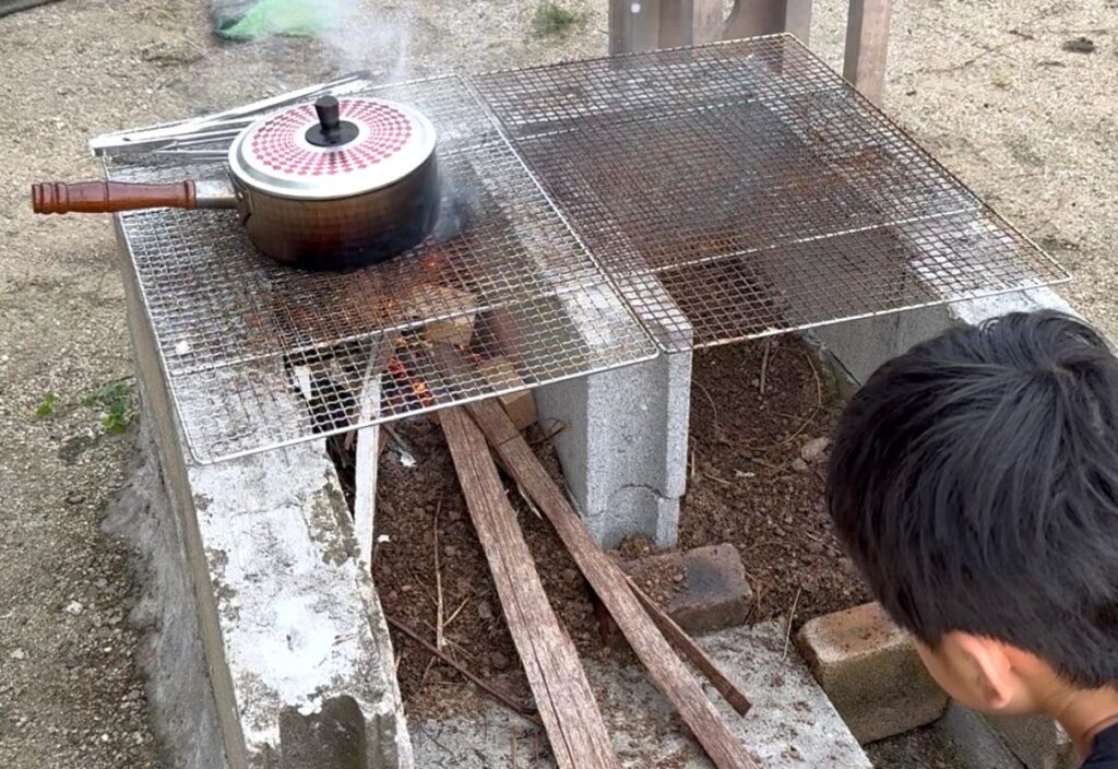 焚火で調理する子ども